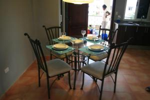 una mesa de comedor con sillas y una mesa con platos y vasos. en Bavaro Green en Punta Cana