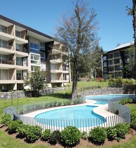 una piscina frente a un edificio de apartamentos en Condominio Parque Payllahue, Pucón Camino al Volcán 960 en Pucón