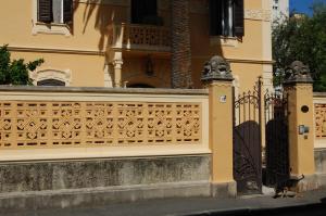 a cat standing next to a fence in front of a house at Arena Alfieri B&B in Livorno