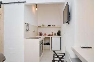 a small white kitchen with a sink and a counter at CASA FLAMI' 3 in Ostuni +12 photos