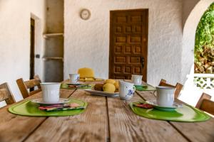 einem Holztisch mit Tellern und Tassen darüber in der Unterkunft Villas Guzman - Flores in Benissa
