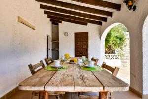 ein Esszimmer mit einem Holztisch und Stühlen in der Unterkunft Villas Guzman - Flores in Benissa + 37 Fotos