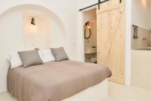 1 dormitorio con 1 cama y puerta de madera en CASA FLAMI' 3, en Ostuni
