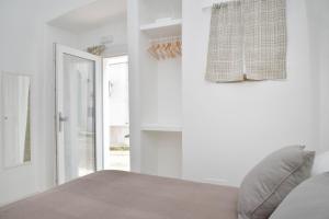 a white bedroom with a bed and a window at CASA FLAMI' 3 in Ostuni