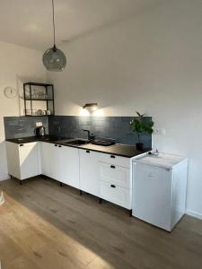 a kitchen with white cabinets and a sink at Apartamenty Komorniki in Komorniki