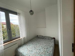 a small bedroom with a bed and a window at Apartamenty Komorniki in Komorniki