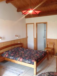 a bedroom with a bed and a ceiling fan at Ferme Auberge L'Ile Sauvage in Bouin