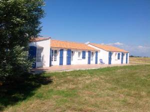 a white building with blue doors on a field at Ferme Auberge L'Ile Sauvage in Bouin +12 photos
