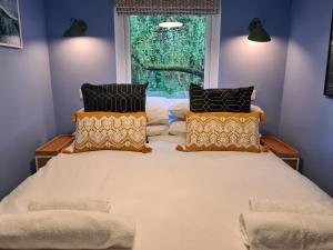 a bedroom with a large bed with a window at Pebble Cottage in Uny Lelant