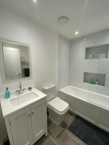 a bathroom with a sink and a toilet and a bath tub at Family Home in Seaside Town in Hastings