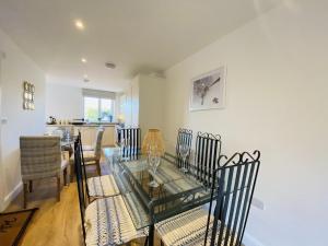 une salle à manger avec une table et des chaises en verre dans l'établissement Family Home in Seaside Town, à Hastings