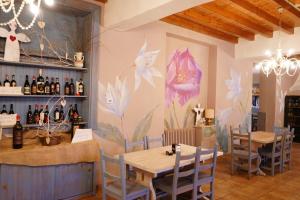 a restaurant with a table and chairs and a wall with flowers at Art Hotel Baldo in Ferraro di Monte Baldo