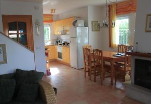 a kitchen and dining room with a table and a refrigerator at Lovely villa in family resort in Miami Platja