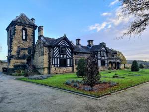 an old stone mansion with a tree in the yard at The Stump Cross inn in Halifax