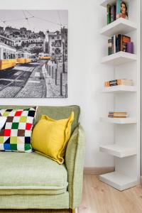 I Love Lisboa Apartment NEW AC في لشبونة: غرفة معيشة مع أريكة خضراء مع وسادة صفراء