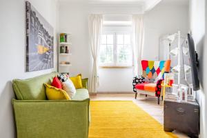 uma sala de estar com um sofá verde e um tapete amarelo em I Love Lisboa Apartment NEW AC em Lisboa