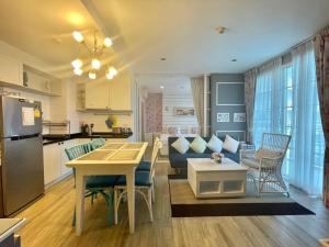 a kitchen and living room with a table and a couch at Summer Huahin Condo 2 Bedrooms Pool View Classic Room in Hua Hin