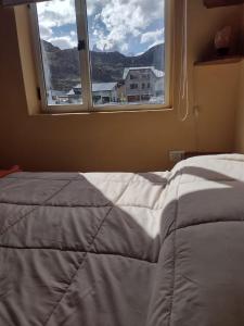 a bedroom with a bed and a window at Paso del Cuadrado in El Chalten