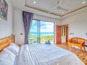 a bedroom with a large bed and a large window at Reef View Villa in Lamai