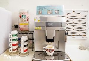 a coffee maker on a counter with cups of coffee at 充電樁 羅東好民宿Cloud BnB 3 雲朵朵3館 免費洗衣機 烘衣機 星巴克咖啡豆 國旅特約店 in Yilan City