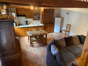 een woonkamer met een bank en een tafel in een keuken bij Maison au calme a l'orée du bois. Accès A13-A14 in Orgeval