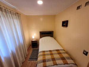 a small bedroom with a bed and a window at Cabañas Dahue in Valdivia +4 photos