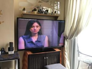 a flat screen tv with a woman on it at Baguio Summer Vacation with Balcony min 2 nights in Baguio