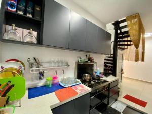 a kitchen with black cabinets and a blue counter top at SWEET HOME SKY GARDEN@BM in Bukit Mertajam