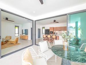 uma sala de estar com uma mesa de vidro e cadeiras brancas em Villa Sumalee - private villa 5 min to the beach em Lamai