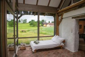 ein Schlafzimmer mit einem Bett und einem großen Fenster in der Unterkunft WALD-LAND-HOF Schloss Rosenau in Schloss Rosenau