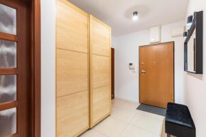 um corredor com uma porta de madeira num quarto em SuperApart Wilanowska 7 em Varósvia