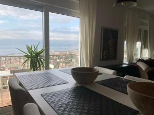 a dining room table with a view of a city at Linden Trsat with balcony in Rijeka