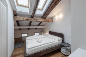 a bedroom with a white bed in a room with windows at Stay COOPER l Laubenhaus in Bolzano