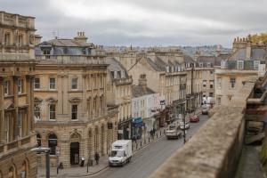 Una vista de una calle de la ciudad con coches y edificios. en Impeccable 4-Bed Apartment in Bath, en Bath