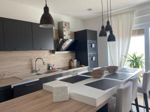 cocina con armarios negros y encimera blanca en Linden Trsat with balcony en Rijeka