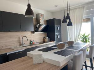 a kitchen with black cabinets and a white counter top at Linden Trsat with balcony in Rijeka