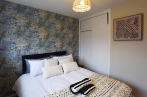 Un dormitorio con una cama con una maleta negra. en Westgate House - 5 bedroom newly renovated house with hot tub & private parking en Canterbury
