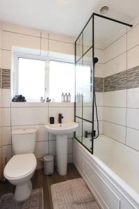y baño con aseo, lavabo y ducha. en Westgate House - 5 bedroom newly renovated house with hot tub & private parking en Canterbury