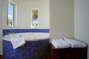 a blue and white bathroom with a tub and two towels at miKasa Agua Amarga & SPA in Agua Amarga