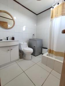 een badkamer met een toilet, een wastafel en een douche bij Amplia y acogedora Casa, a 10 min de playa en auto in Los Molles