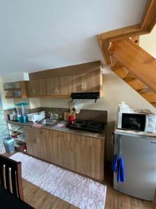 a kitchen with wooden cabinets and a stove top oven at Baguio Summer Vacation with Balcony min 2 nights in Baguio