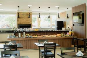 a restaurant with tables and chairs and a counter at Pousada Saint Diniz in Monte Sião