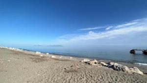 una spiaggia con rocce e un molo in acqua di Al Saliceto Hotel a Patti