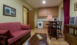 a living room with a couch and a table and a kitchen at Apartamentos Villa de Cabrales in Arenas de Cabrales +8 photos