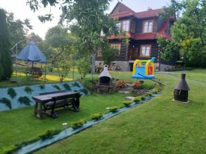 un patio trasero con una mesa de picnic y un parque infantil en Willa Świt, en Maków Podhalański