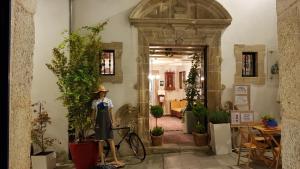 a woman standing in front of a door with a bike at Hotel Monumento Pazo de Orbán in Lugo