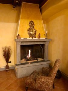 a living room with a fireplace and a chair at Casa Flora in Civitella dʼAgliano