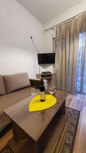 a wine bottle and two glasses on a table in a living room at Apartment SIDRO Tivat in Tivat