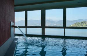 a swimming pool with a view of the water at Il Porticciolo in Laveno-Mombello