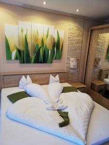 sypialnia z 2 białymi łóżkami i obrazem na ścianie w obiekcie Kék Lagúna Wellness Apartmanok w Egerszalók
